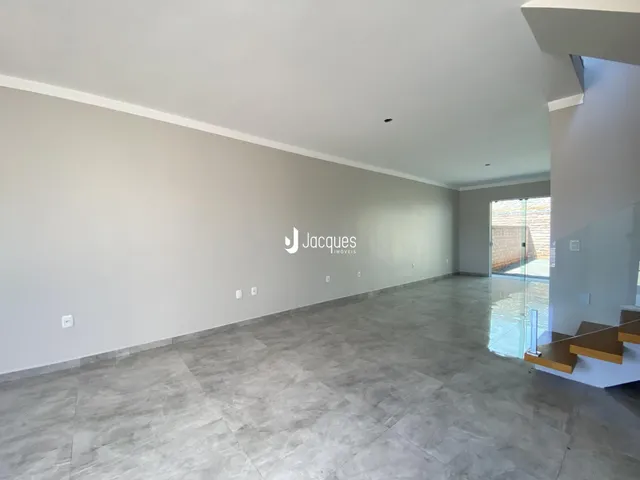 Espaço interno amplo com piso de cerâmica e paredes brancas.