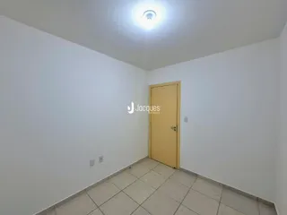 Corredor com paredes brancas e piso de cerâmica.