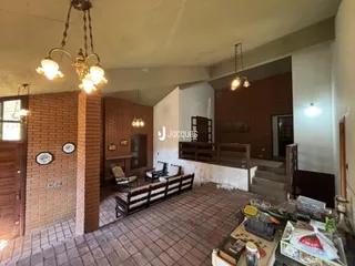 Imagem de uma sala com paredes de tijolo aparente e piso de cerâmica.