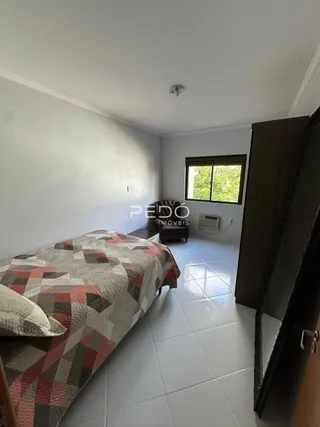 Quarto com cama e piso de cerâmica claro.