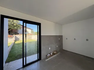 Vista da sala de estar com acesso a um pátio gramado.