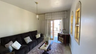 A sala de estar apresenta um sofá escuro e cortinas claras.