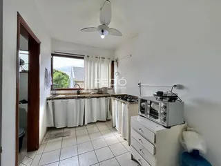 Cozinha com piso de cerâmica e armários brancos.