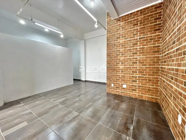 Ambiente interno com piso de cerâmica e parede de tijolos à vista.