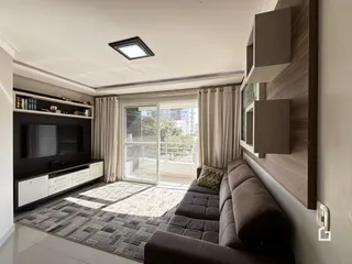 Sala de estar com sofá e televisão em um apartamento.