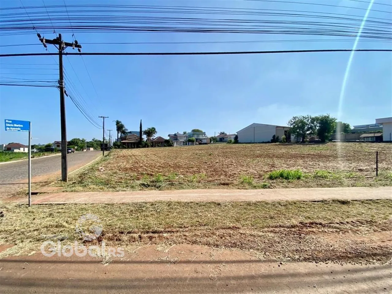 Campo aberto com vegetação seca e estrada no primeiro plano.
