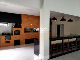 Cozinha moderna com armários de madeira e bancadas escuras.