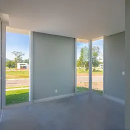 Vista interna de um ambiente com grandes aberturas para o exterior.