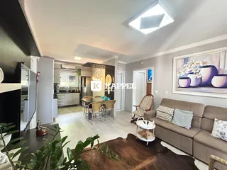 Uma sala de estar e jantar com sofá e mesa de madeira clara.