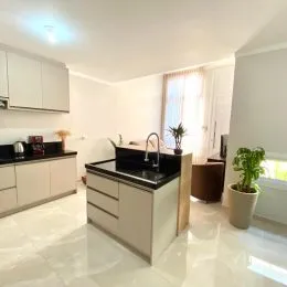 Foto de uma cozinha com armários brancos e bancada clara.