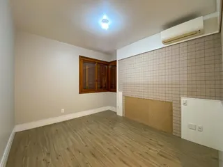 Sala de estar com piso de madeira e parede texturizada.