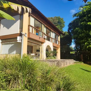 Fachada de uma casa em Lajeado, Brasil, com jardim verde em primeiro plano.