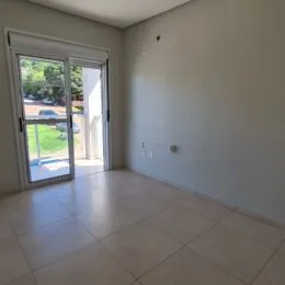 Sala de estar com porta de vidro que dá acesso ao exterior.