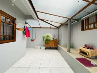 Foto de um ambiente interno com teto inclinado e piso de cerâmica.
