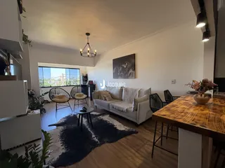 Sala de estar moderna com piso de madeira e vista para a paisagem.