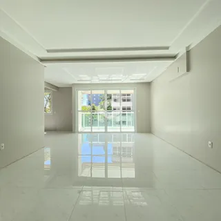Interior de um corredor com grande porta de vidro refletindo a luz.