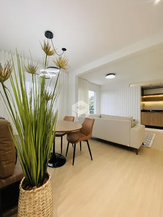 Ambiente de sala de estar e jantar com piso de madeira clara.