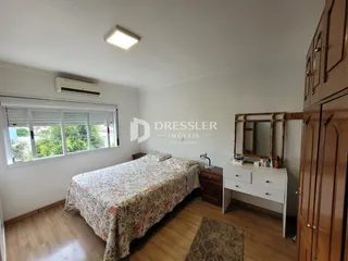 Quarto com cama e armário de madeira em um imóvel no Brasil.