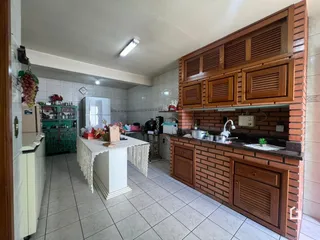 Uma cozinha com armários de madeira e piso de cerâmica.