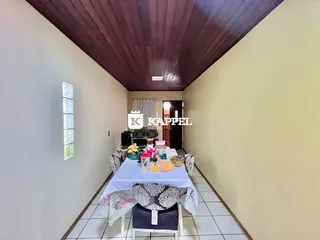 Uma sala de jantar com mesa posta e piso de cerâmica.