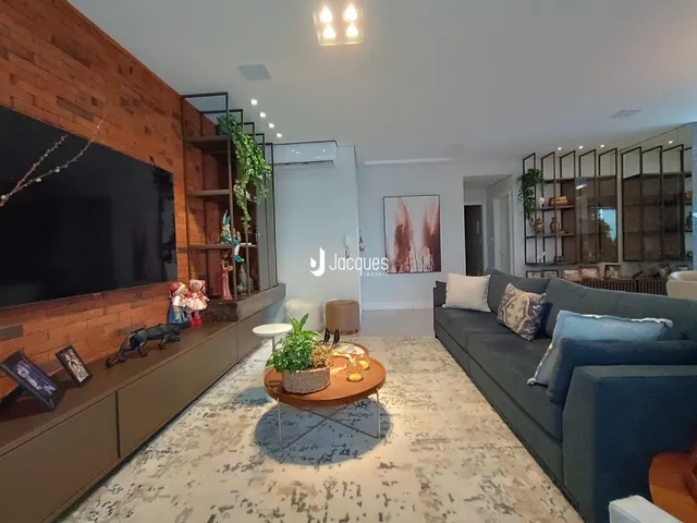 Sala de estar com parede de tijolos aparentes e sofá moderno.