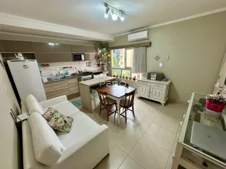 Sala de estar com cozinha e sala de jantar em um apartamento no Brasil.
