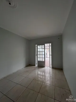 Hall de entrada com piso de cerâmica e porta de vidro.