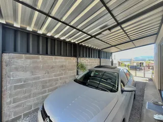 Fachada de construção com parede de tijolos e telhado metálico.