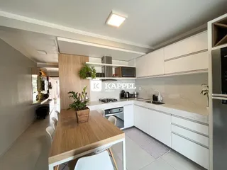 Foto de uma cozinha moderna com armários brancos e bancadas claras.