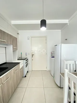 Vista da cozinha com armários e piso claro.