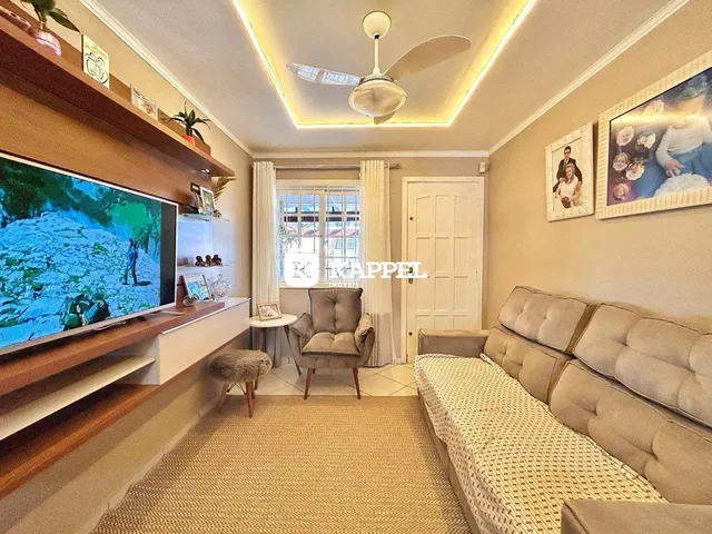 Sala de estar com sofá e televisão em um ambiente bem iluminado.