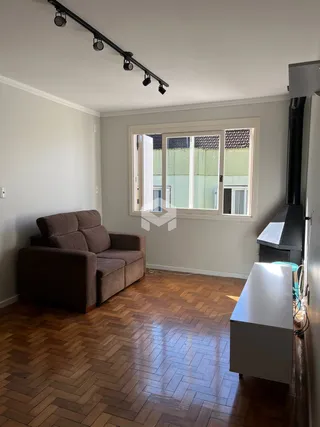Sala de estar com piso de madeira e janela.