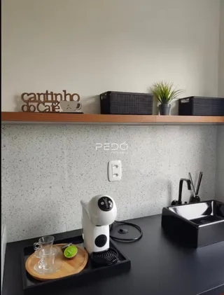 Vista da bancada da cozinha com pia e eletrodomésticos.