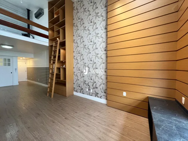 Interior de uma sala com piso de madeira e parede decorada em Lajeado.