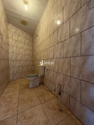 Foto de um corredor com revestimento de azulejos em um imóvel.