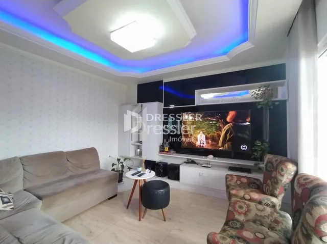 Sala de estar com sofá e televisão em um imóvel no Brasil.