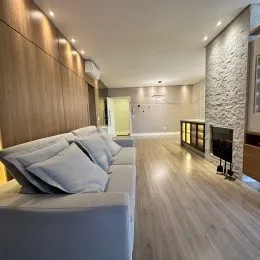 Hall de entrada com painéis de madeira e piso claro.
