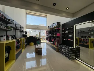Imagem de um espaço interno com estantes e piso claro.