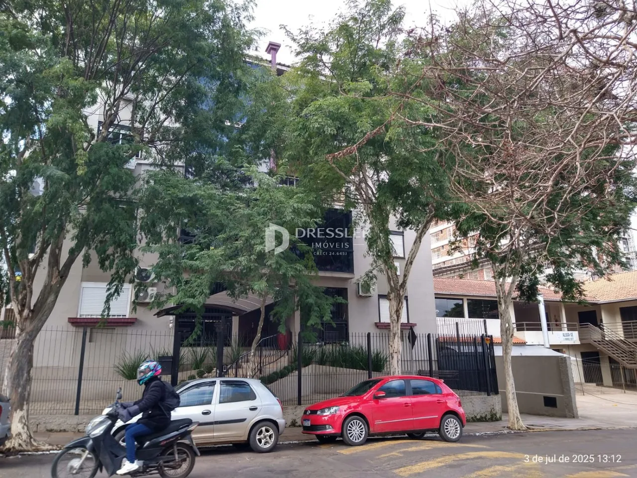 Fachada de um imóvel residencial em Lajeado, Brasil, com árvores em primeiro plano.