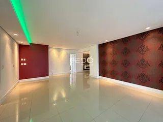 Ambiente interno de uma sala ampla com piso claro e paredes em tons de vermelho e marrom.