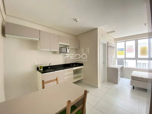 Foto de uma cozinha moderna com armários brancos e bancadas escuras.