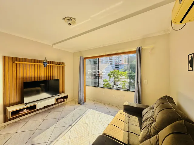 Sala de estar com parede de madeira e janela de vista para a cidade.