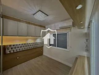 Quarto com cabeceira estofada e piso de madeira clara.