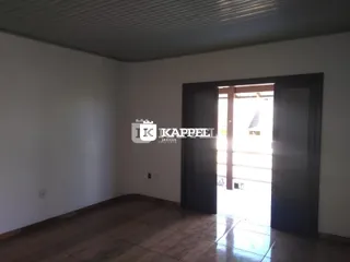 Sala de estar com piso de madeira e paredes brancas.