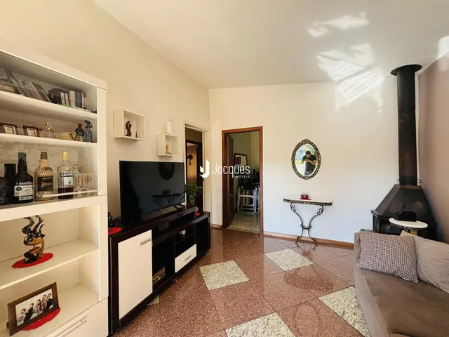 Foto de uma sala de estar com estantes e lareira em um imóvel no Brasil.