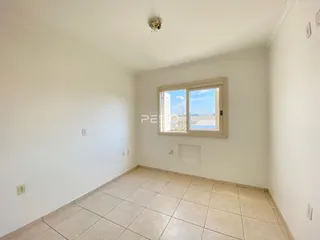 Foto de um cômodo interno com piso de cerâmica claro e paredes brancas.