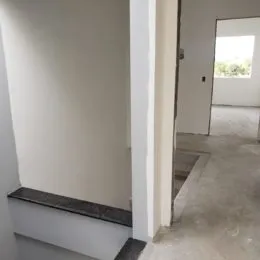 Vista interna de um corredor com paredes brancas.