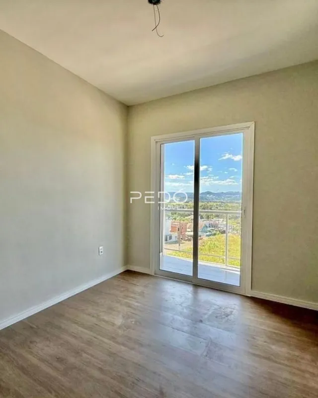 Sala de estar com vista para a paisagem externa através da janela.
