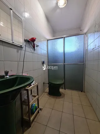 Foto de um banheiro com revestimento de azulejos brancos.