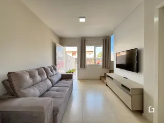Sala de estar com sofá e televisão em um apartamento no Brasil.